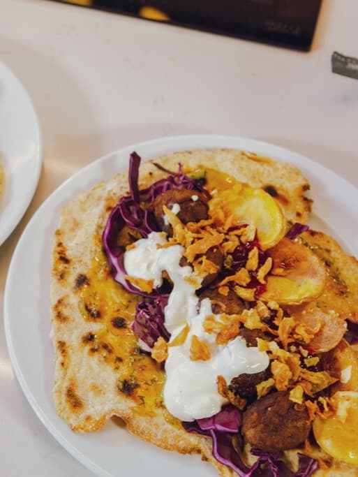 Auf einem weißen Teller liegt ein Schwedischer Köttbullar Knäcketaco