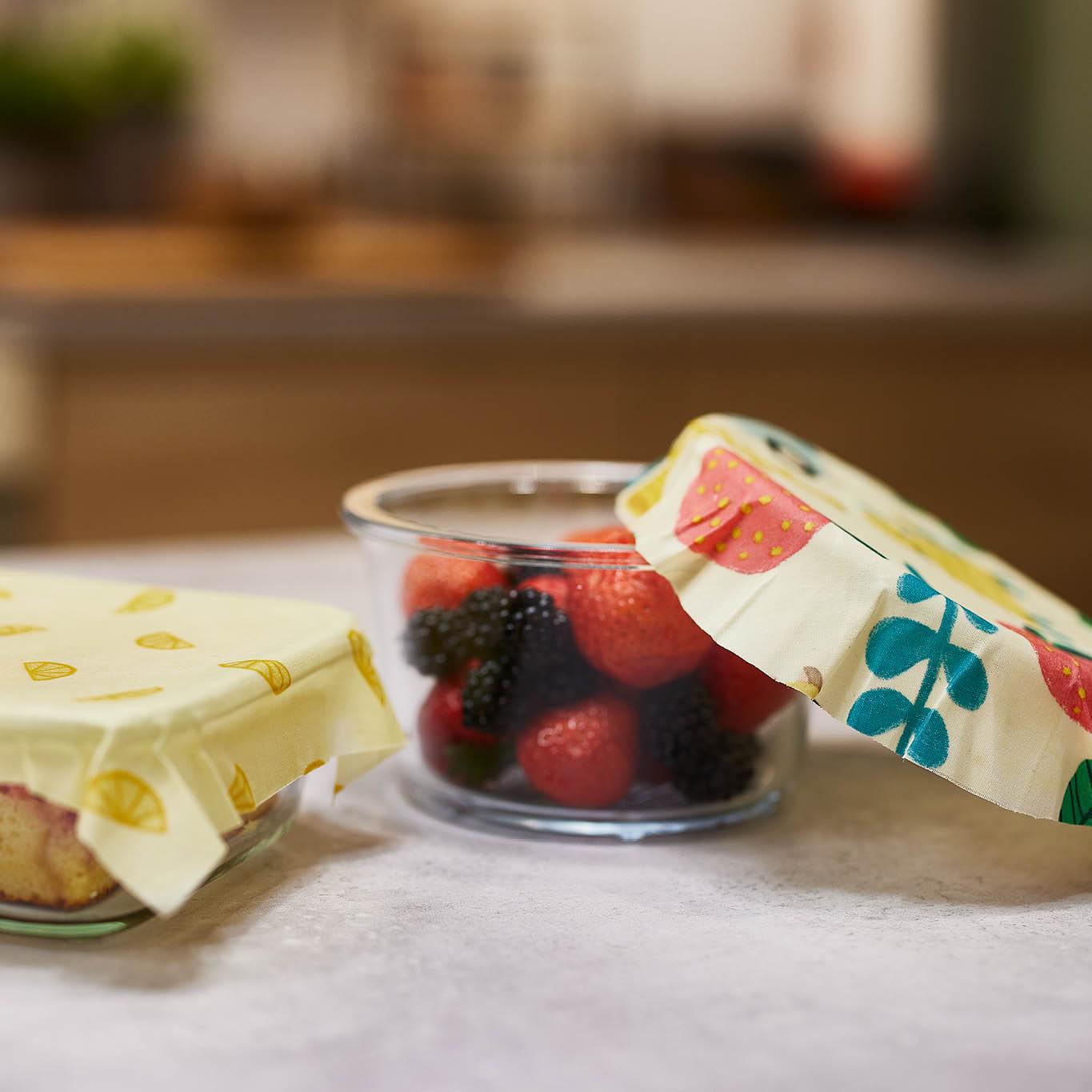 Auf einem weißen Tisch steht ein kleines Glas mit Beeren darin.