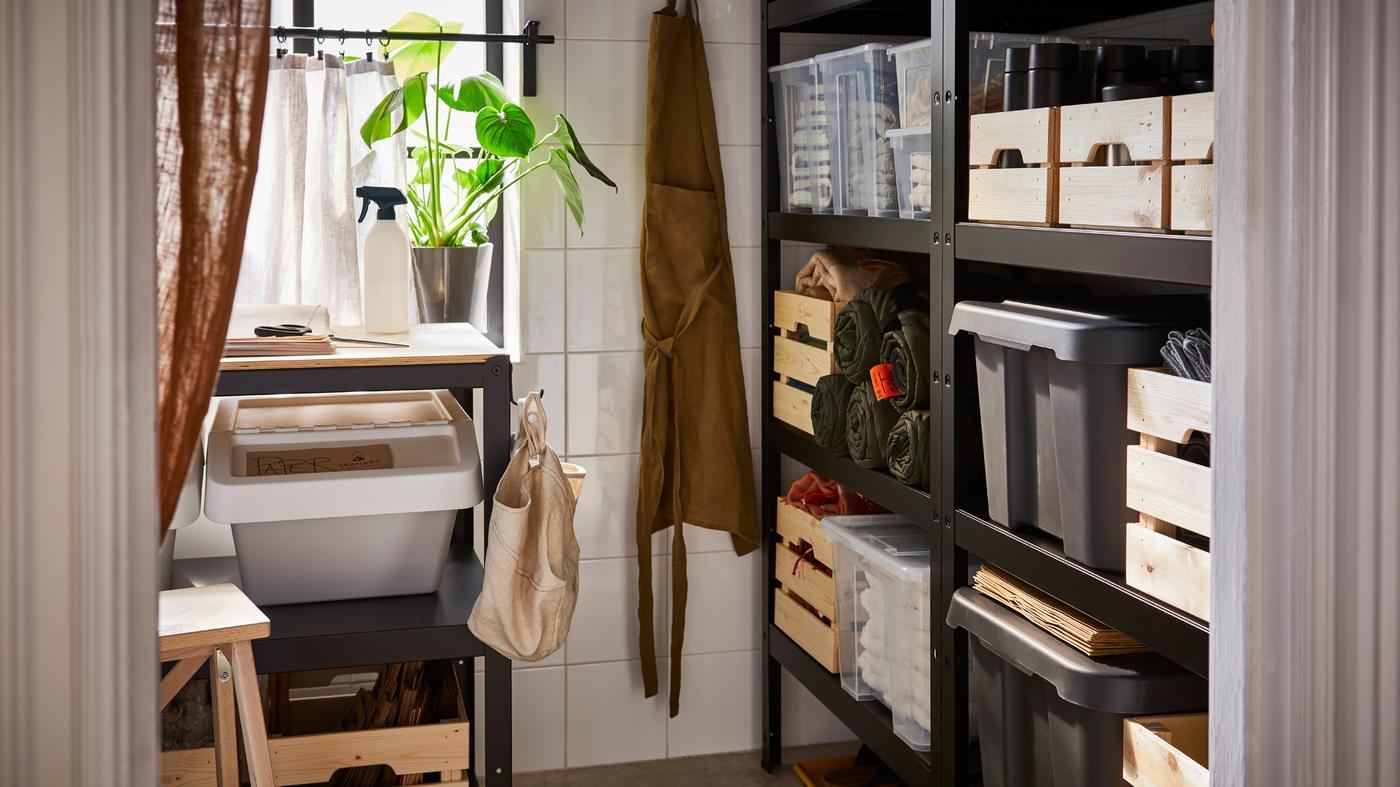 Aufbewahrungslösung für eine Frühstückspension. Aufbewahrungsraum mit schwarzen BROR Regalen an einer und einer BROR Werkbank an der anderen Wand unter einem Fenster.