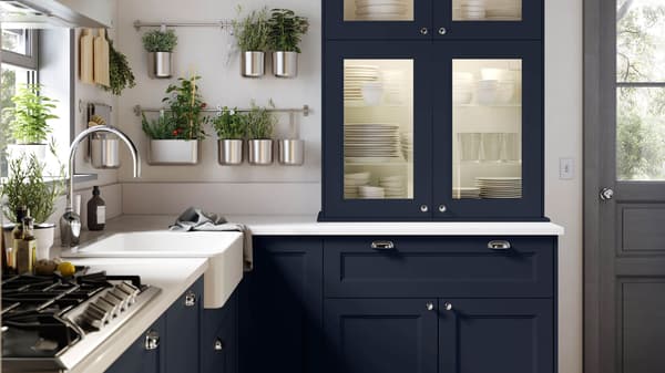 AXSTAD blue kitchen fronts in a kitchen with green plants hanging on the wall.
