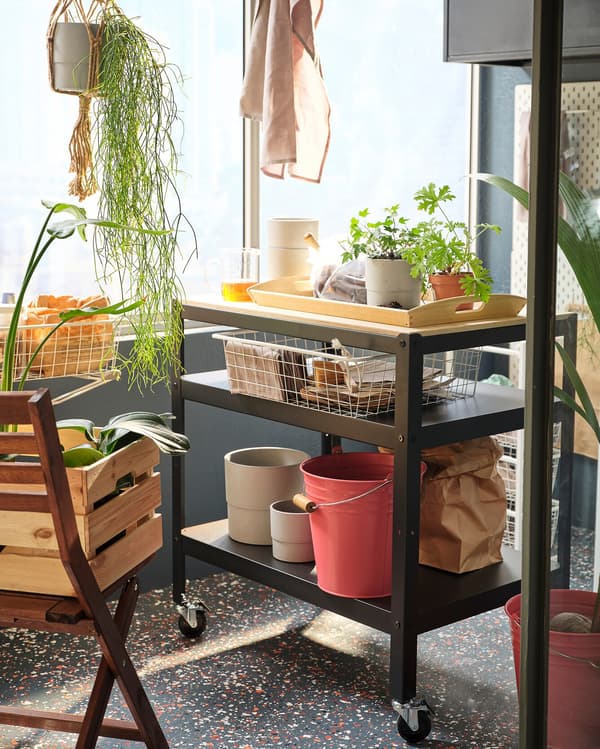 Az erkélyen zsúrkocsin kerti kiegészítők sorakoznak.