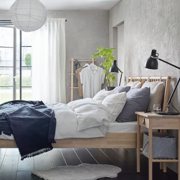 Babmusowy stół z krzesłami ratanowymi w białej kuchni.