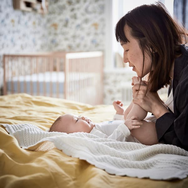 Baby on a bed with a woman