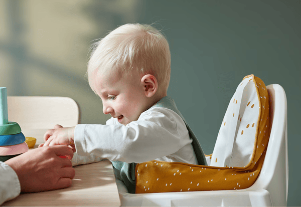 baby playing while sitting in a highchair