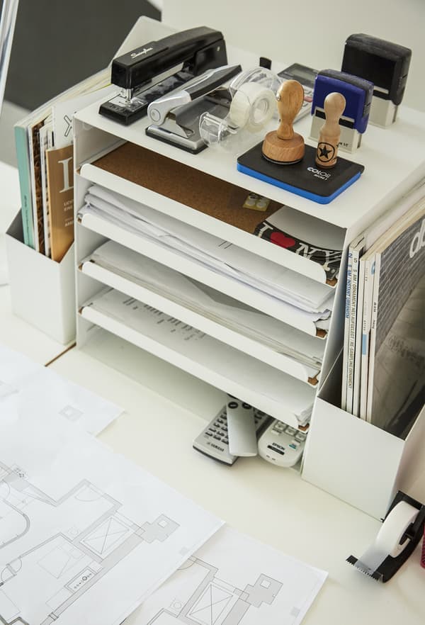 Bac à courrier et fournitures de bureau, sur un bureau.