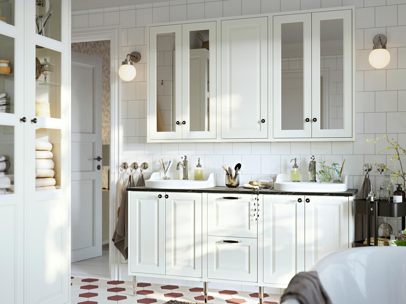 Badkamer met witte TÄNNFORSEN wastafelkasten met deuren en lades, spiegelkasten met deuren en een hoge kast.