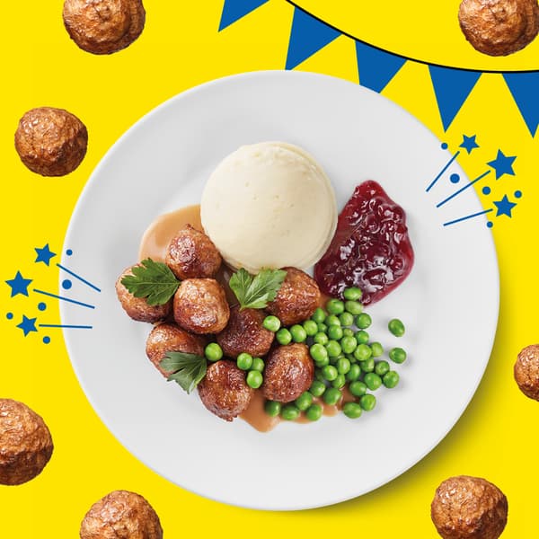Bällchenteller mit Kartoffelpüree, Erbsen und Preiselbeermarmelade auf einem gelben Hintergrund mit blauer Girlande.