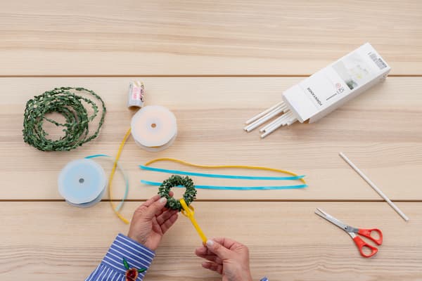 Bänder werden um den kleinen Kranz befestigt.