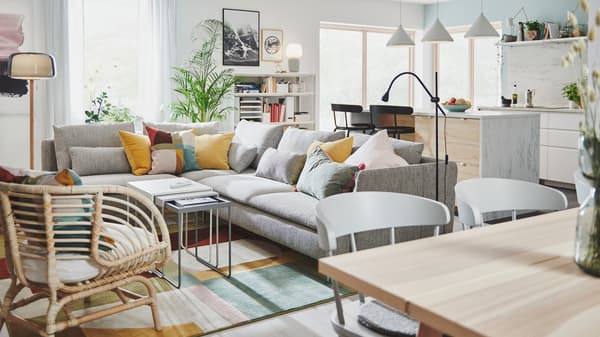 Bahagian bilik yang besar dengan ruang dapur yang mempunyai pulau dapur, di sebelah ruang tamu yang mempunyai sofa penjuru yang besar.