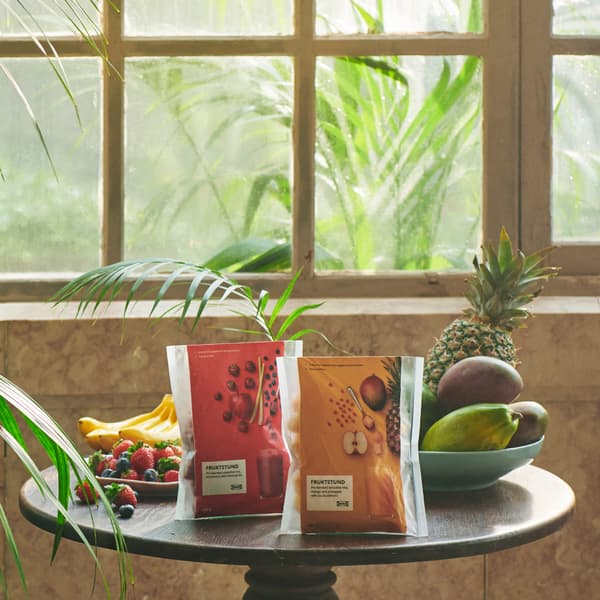 Balení dvous druhů smoothie FRUKSTUND na stolečku před oknem