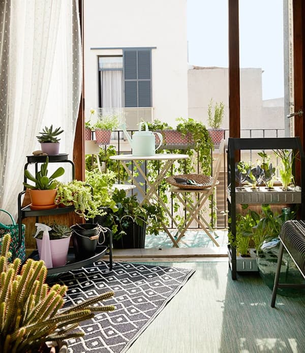 Balkon met een tuinset die is omringd door plante.