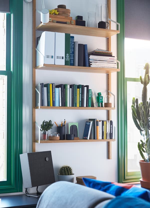 Bamboe IKEA SVALNÄS wandkastcombinatie met boeken en papieren op 4 planken.