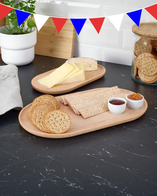 Bandejas de madera con galletas y dips sobre una mesa de terraza.