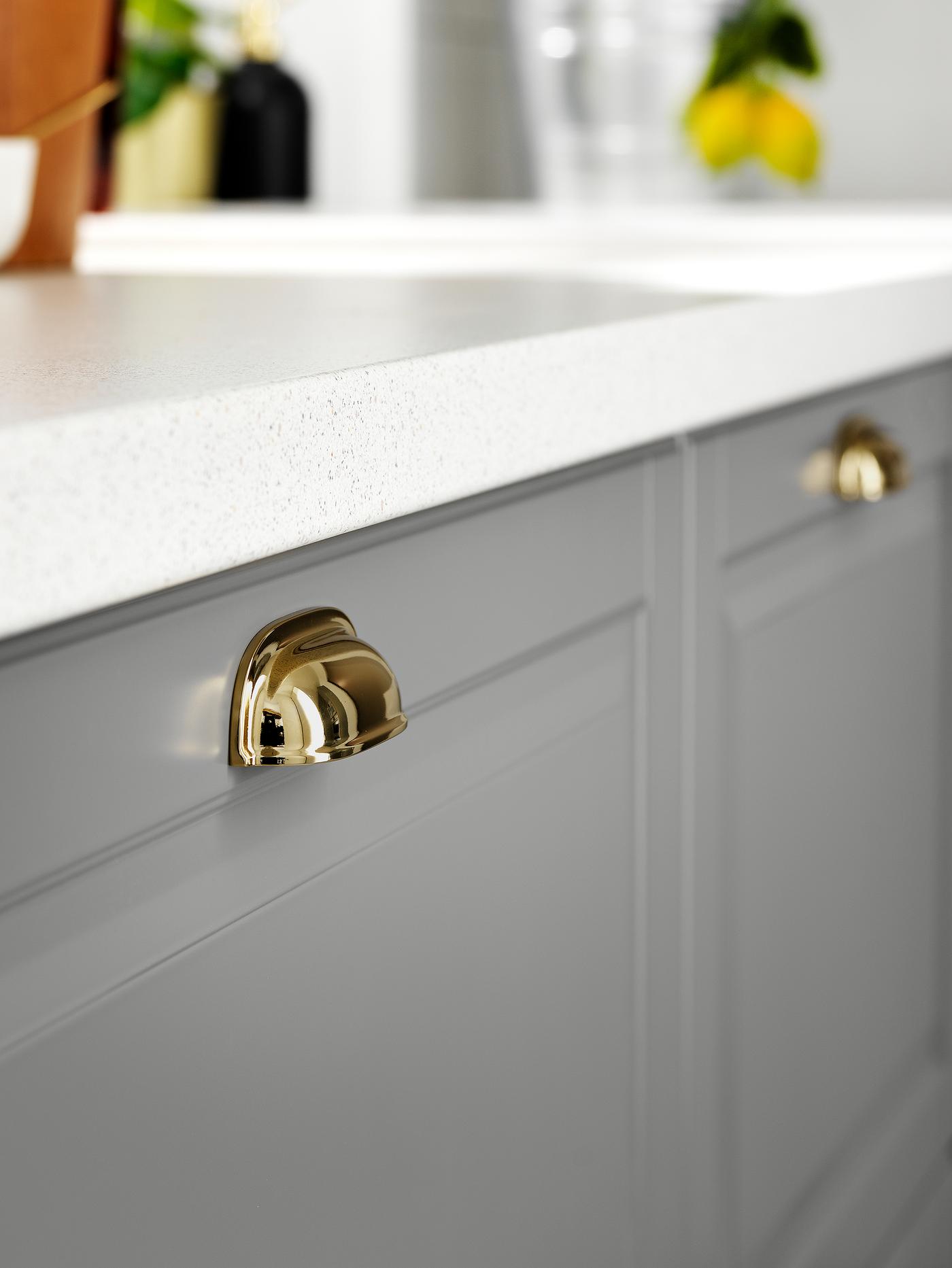 Base cabinets with grey drawer fronts and brass-coloured cup handles.