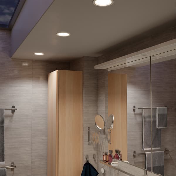 Bathroom ceiling with three LED recessed spotlights that are dimmable, a TRÅDFRI remote is mounted on the wall below.