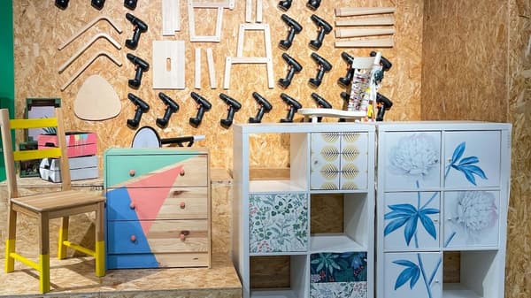 Bearbeitete Möbel aus dem Zweite-Chance-Markt stehen vor einer Holzwand.