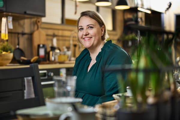 Beate Hagen sitter på et IKEA kjøkken og smiler mot kamera. 