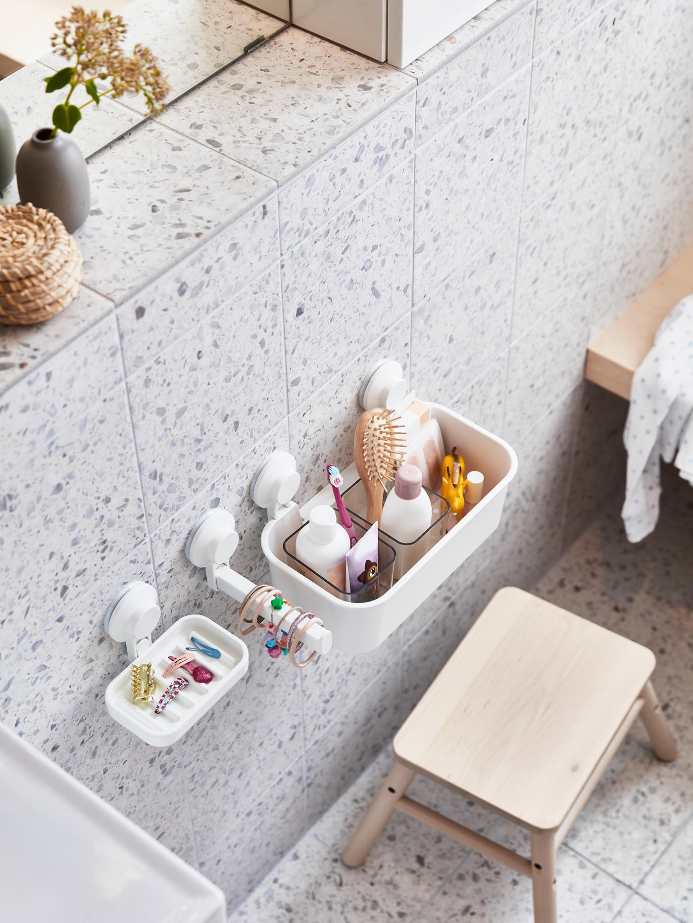 Beauty products ordered in a box with compartments, sitting on a wall shelf together with other elegant storage.