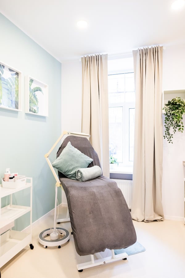 Beauty treatment room with a recliner chair, soft cushions, and bright natural light.