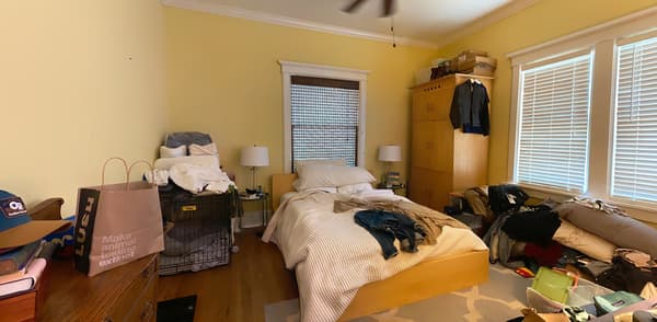 Bedroom with a bed with some clothes on the bed