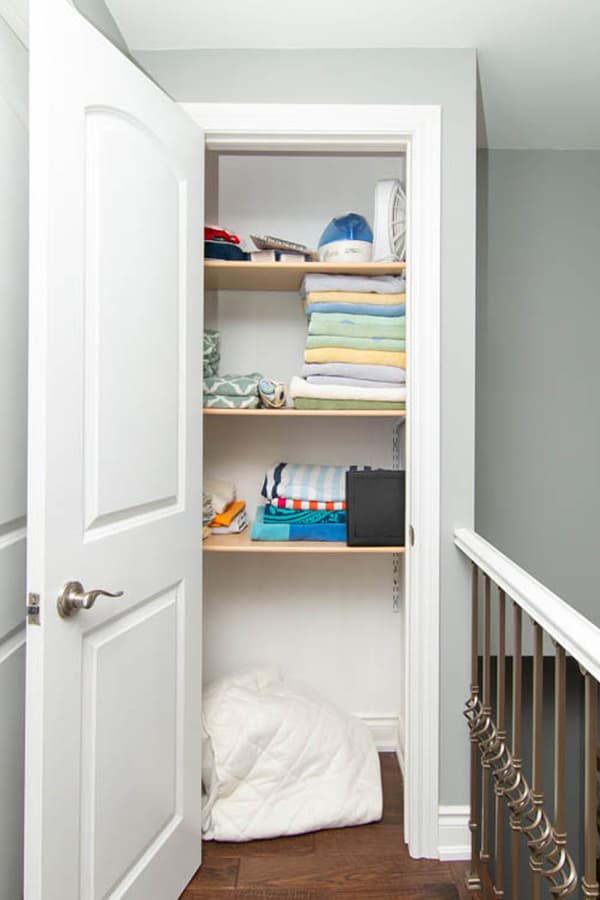 Before shot of Megan's hallway linen closet, with towels, miscellaneous items, and lots of unused space.