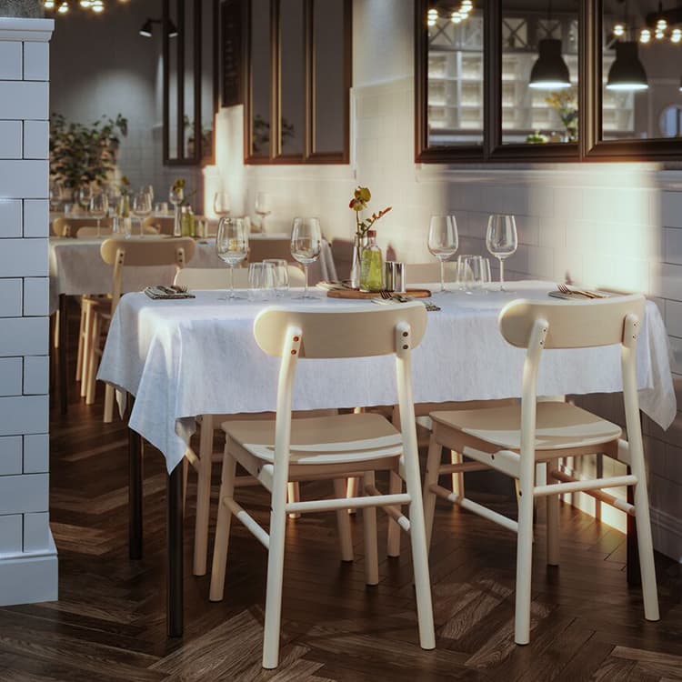 Beige eetkamerstoelen met een tafel waarop een wit tafelkleed ligt