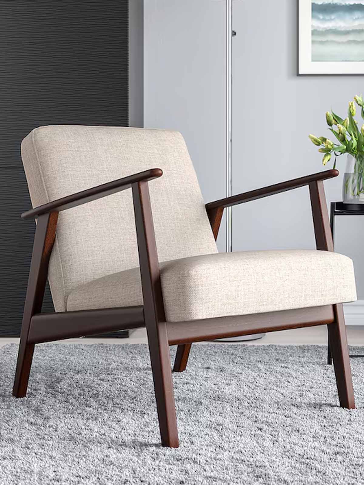 Beige EKENASET armchair in living room with a potted plant on the coffee table in the background.