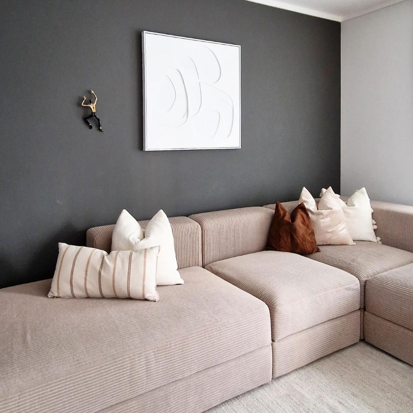 Beige JÄTTEBO modulsoffa mot mörkgrå vägg.