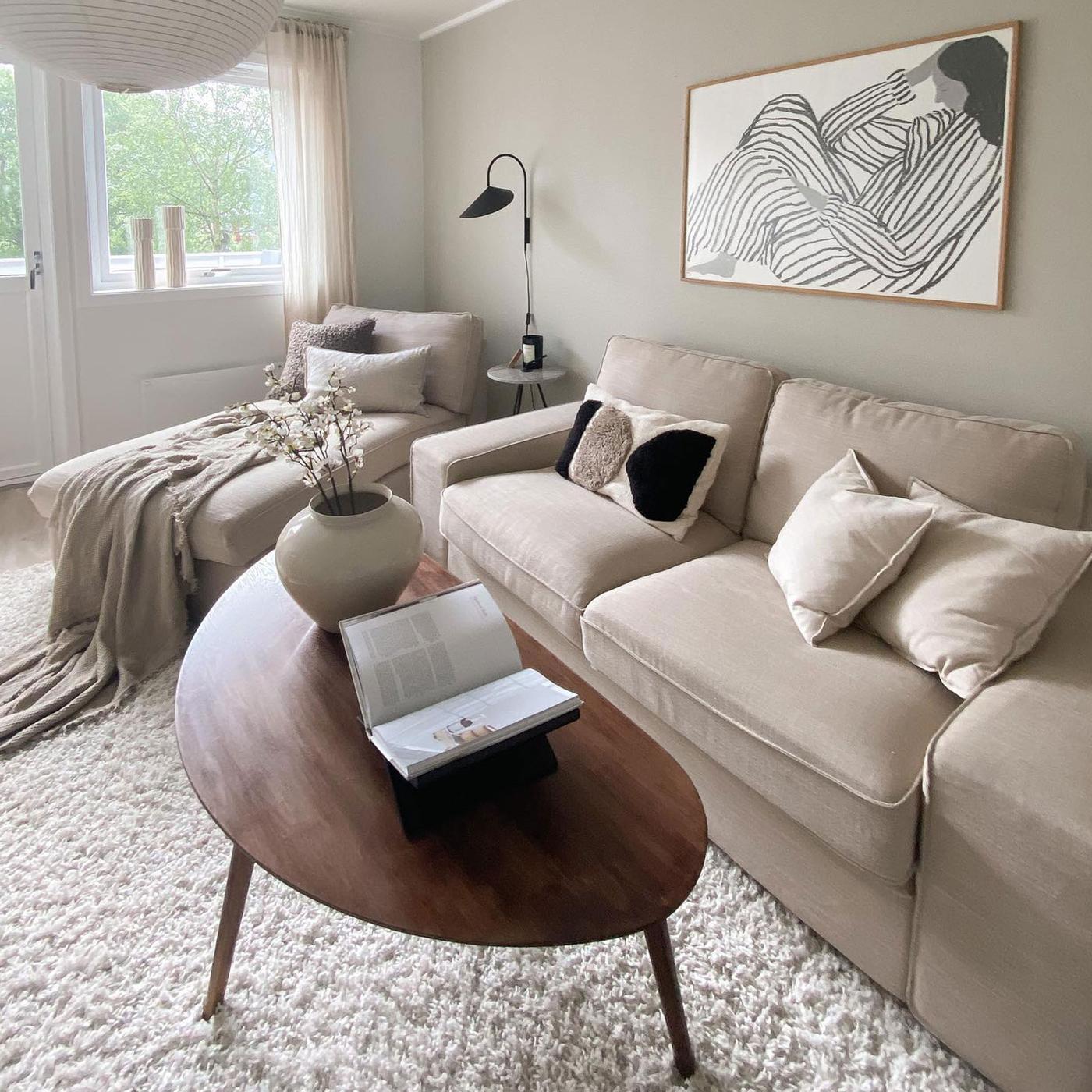 Beige KIVIK schäslong och tresits soffa med ovalt soffbord i mörkt trä. 2026-02