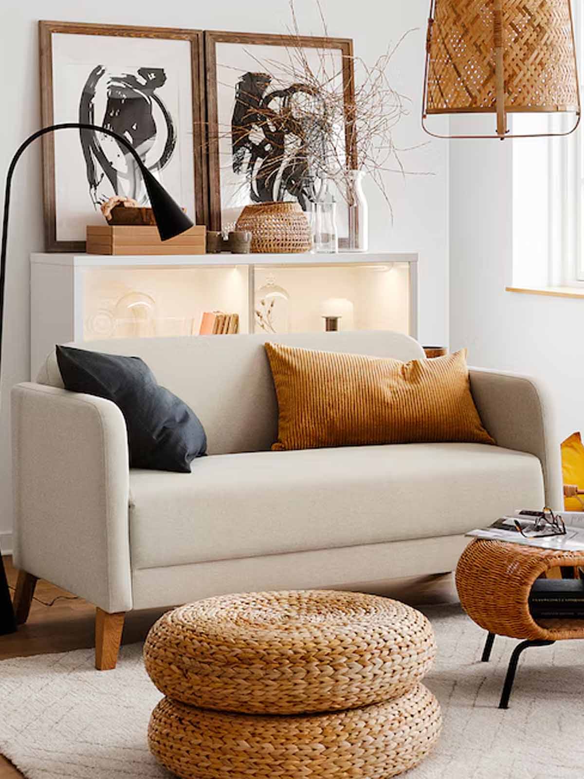 Beige LINANAS sofa with rattan pouffe in the living room.