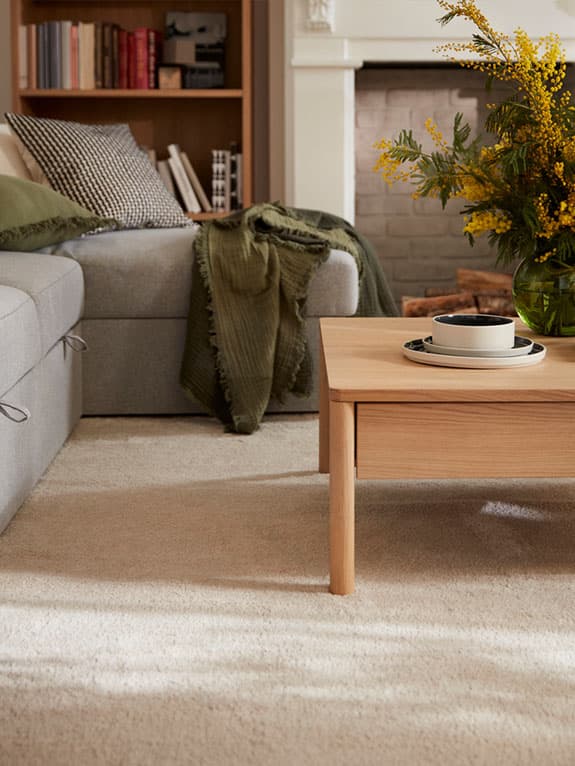 Beige rug in living room with coffee table and couch on it