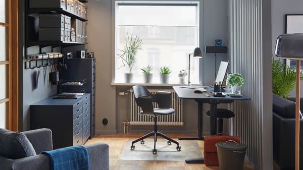 BEKANT linoleum blue/black sit/stand desk in a colour-coordinated workspace with a conference chair and storage.