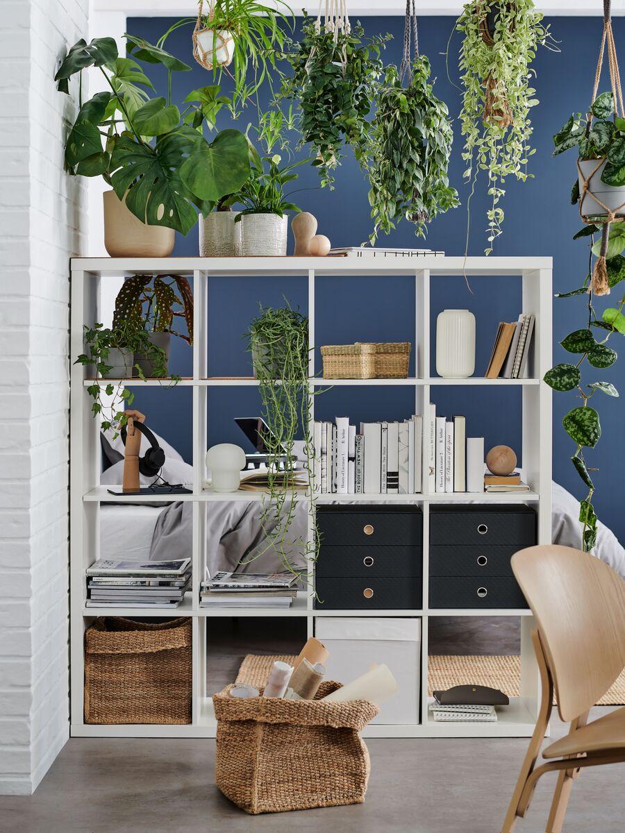 Bela regalna enota KALLAX sredi prostora