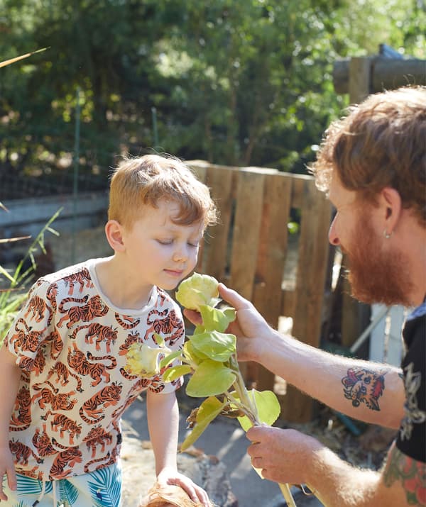 Ben ยื่นดอกไม้ให้ลูกชายของเขาดมในสวน