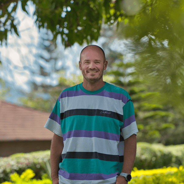 Ben, Sustainability Business Partner, steht draußen im Grünen und lächelt.