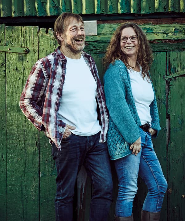 Bernd e Claudia davanti a una porta di legno verde all'esterno.