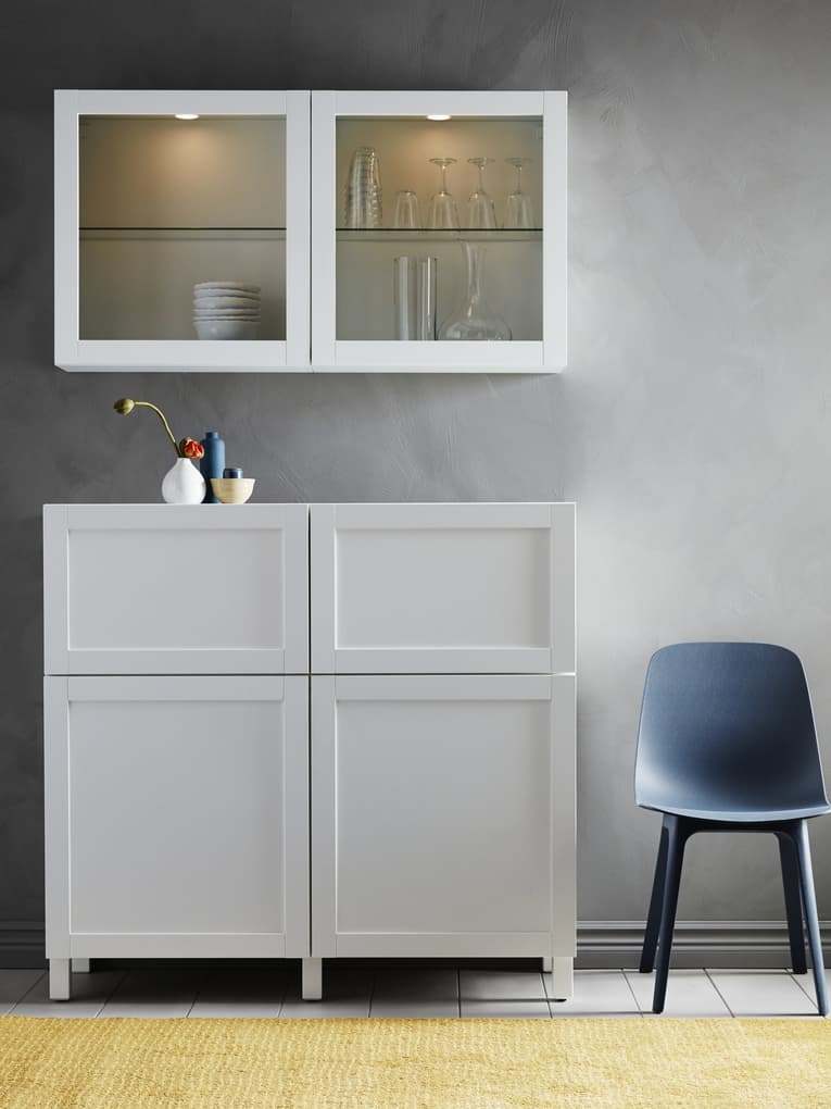 BESTA cabinet with glassvik doors and grey fronts, next to ODGER chair in blue.