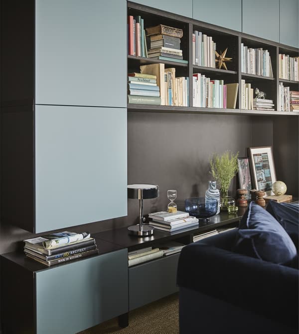 BESTÅ storage with doors are mounted on the wall and standing on the floor in a modern living room.