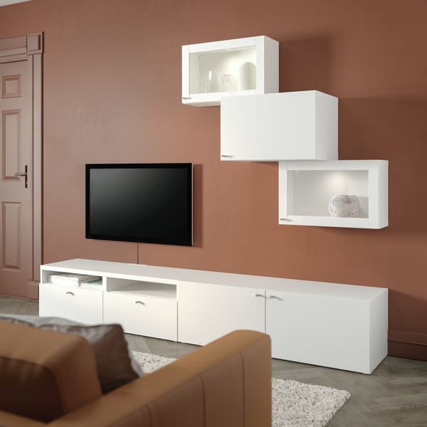 BESTÅ white cabinets on a red-brown wall.