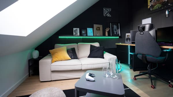 Beżowa sofa KIVIK w pokoju gracza z czarnymi ścianami i skosem.