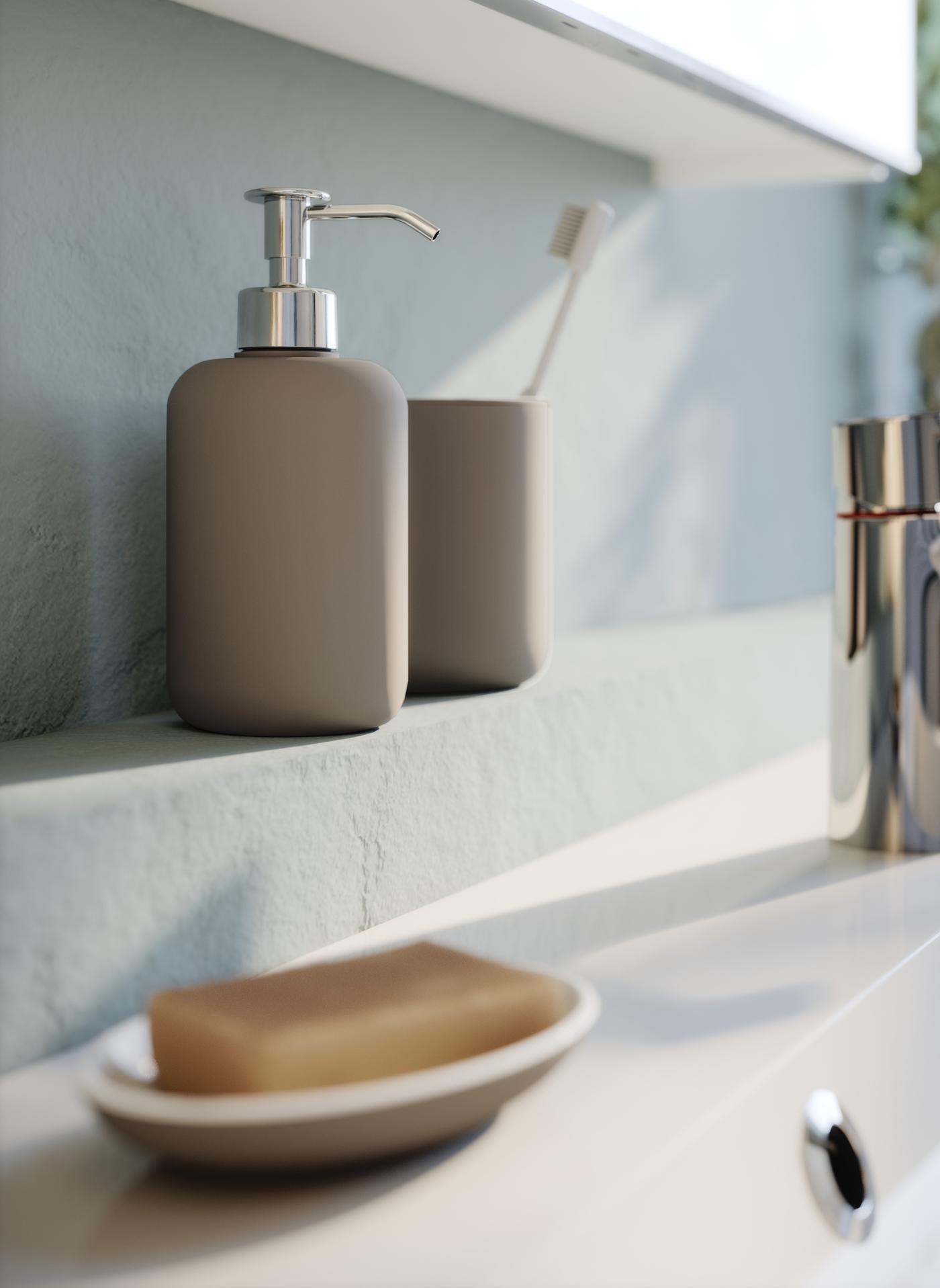 Beżowy dozownik, kubek i mydelniczka stoją na blacie w łazience.