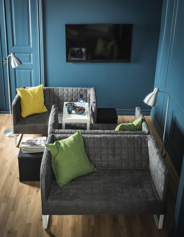 Bi sofa txiki, bata bestearen aurrean; horietako baten bizkarraldea beste sofa baten bizkarraldearen kontra dago.