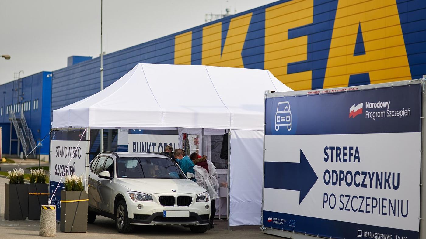 Biały namiot punktu szczepień na tle sklepu IKEA.