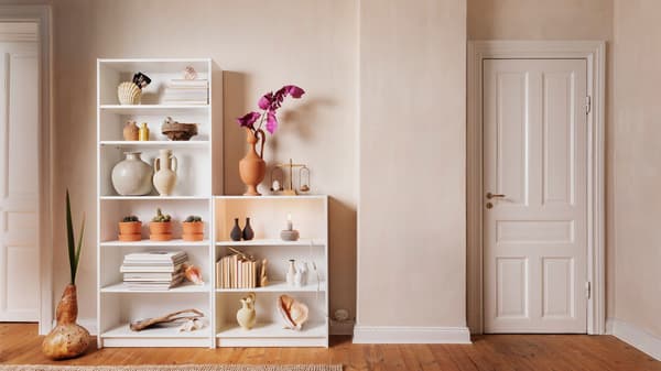 Bibliothèques blanches avec de la décoration dedans.