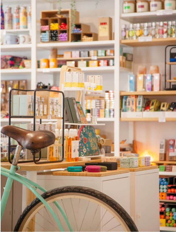 Bicicleta vintage i mobles amb productes de cosmètica natural en una botiga acollidora i ben organitzada.