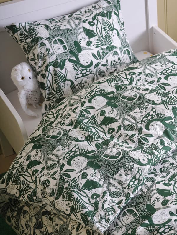 Biela plyšová sova SKOGSDUVA v posteli s obliečkami SKOGSDUVA.