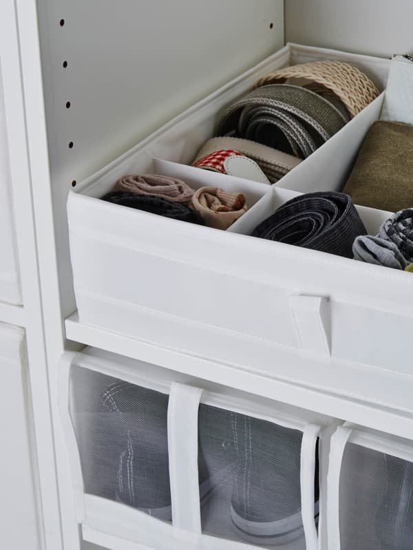 Biela škatuľa s priehradkami SKUBB plná drobností v bielej šatníkovej skrini.