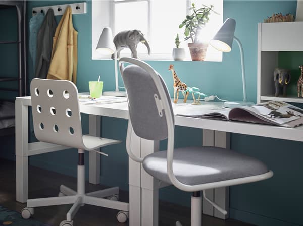 Biela stolička IKEA ÖRFJÄLL a plastová detská stolička JULES vedľa dvoch bielych stolov PÅHL.