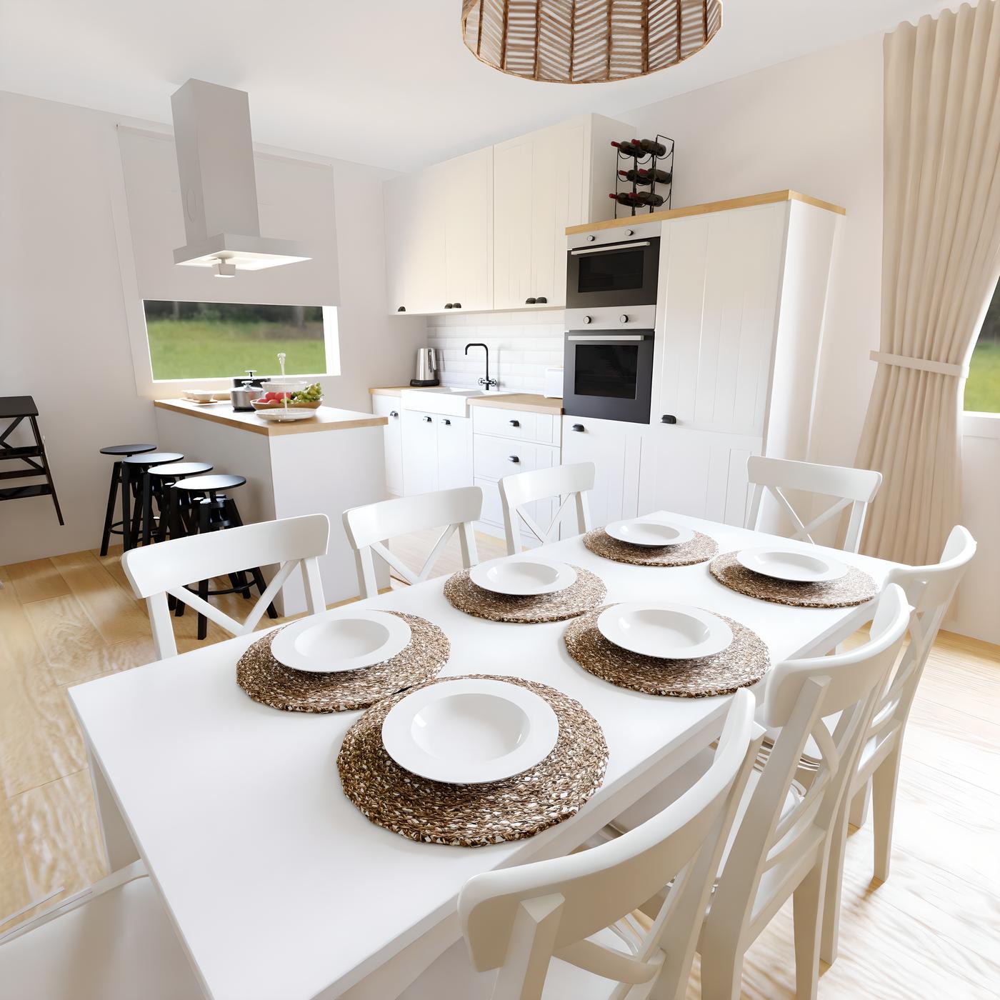 Bijela kuhinja s drvenim podom, stolom i stolicama. Na stolu su bijeli tanjuri na pletenim podmetačima.