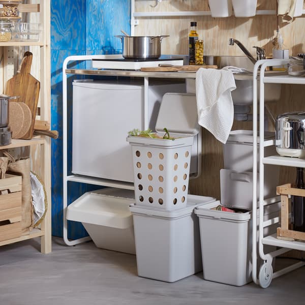 Bijela SUNNERSTA mini kuhinja, sustav za odlaganje od borovine i svijetlosive kante za razvrstavanje otpada različitih veličina i oblika.